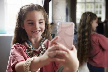 Girl Playing Dressing Up Game Taking Selfie On Mobile Phone