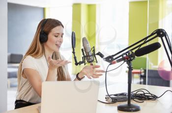 Young woman broadcasting in a studio gesturing, close up