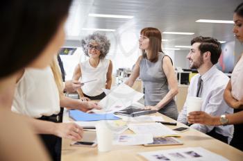 Group of business colleagues brainstorm in open plan office