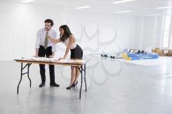 Businessman and woman discussing plans for office design