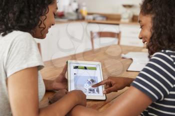 Two Teenage Girls Using Social Media On Digital Tablet