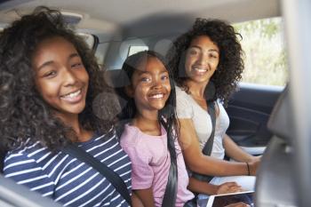 Portrait Of Family With Teenage Children In Car On Road Trip