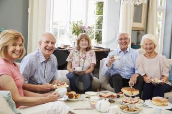 Portrait Of Senior Friends Enjoying Afternoon Tea At Home