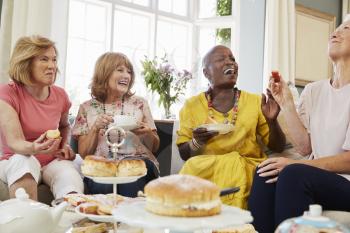 Senior Female Friends Enjoying Afternoon Tea At Home Together
