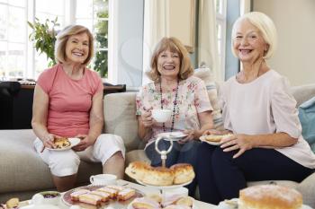 Portrait Of Senior Female Friends Enjoying Afternoon Tea At Home