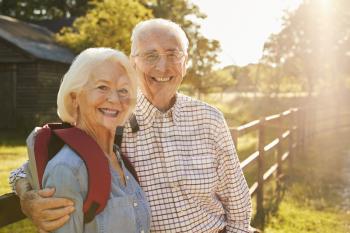 Portrait Of Senior Couple Hiking In Countryside Together