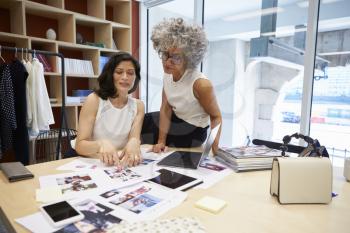 Two female creatives discussing magazine layout in an office