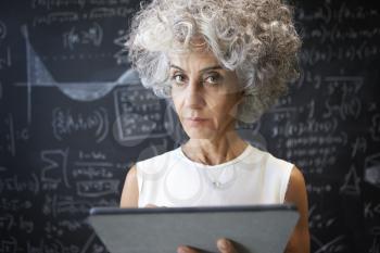Middle aged academic woman using tablet looking to camera