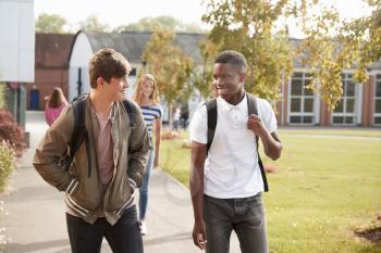 Male Teenage Students Walking Around College Campus Together