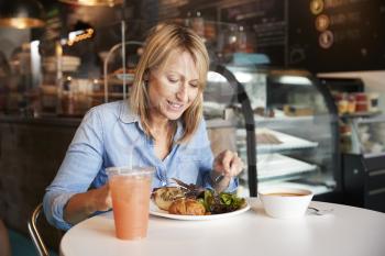 Woman In Coffee Shop Sitting At Table Eating Healthy Lunch