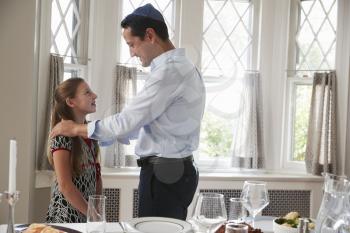Jewish man standing with daughter before Shabbat meal