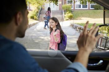 Father In Car Dropping Off Daughter In Front Of School Gates