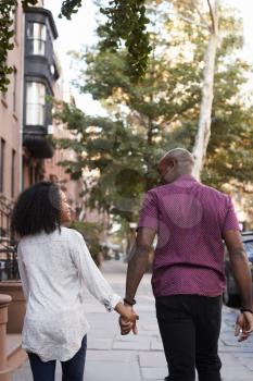 Rear View Of Couple Walking Along Urban Street In New York City