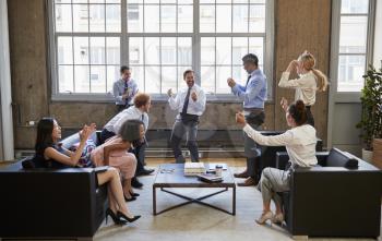 Business team celebrate hitting target at informal meeting