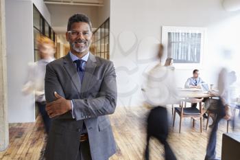 Portrait of middle aged black man in a busy modern workplace