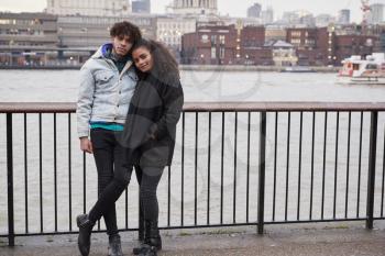 Portrait Of Couple Walking Along South Bank On Visit To London