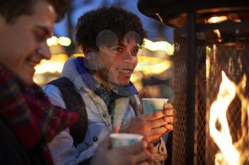Male Friends Drinking Mulled Wine At Christmas Market
