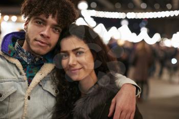 Portrait Of Young Friends Enjoying Christmas Market At Night