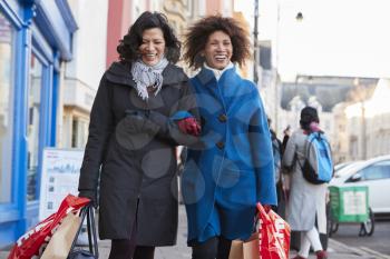 Two Mature Female Friends Enjoying Shopping In City Together