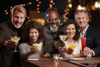 Portrait Of Middle Aged Friends Celebrating In Bar Together