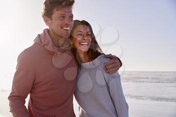 Romantic Couple On Walking Along Winter Beach Together