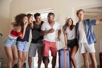Group Of Friends Arriving At Summer Vacation Rental