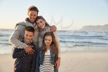 Portrait Of Family Walking Along Winter Beach Together