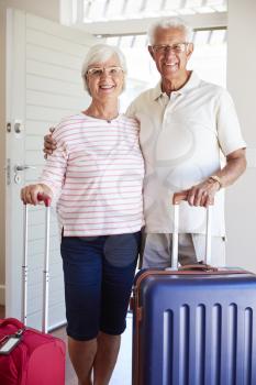 Portrait Of Senior Couple Arriving At Summer Vacation Rental