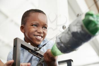 Young black boy using air pressure rocket at science centre