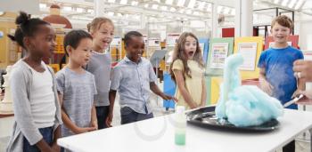 Kids having fun watching an experiment at a science centre