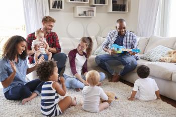 Adult friends entertaining their toddlers in sitting room