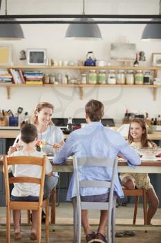 Family having lunch together in their kitchen, vertical