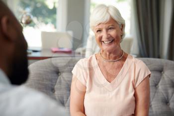 Happy senior woman taking financial advice at home