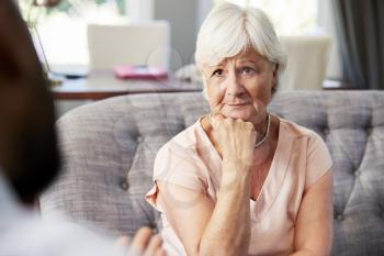 Depressed senior woman having therapy with psychologist