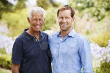Portrait Of Senior Father With Adult Son On Walk In Park
