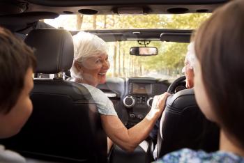 Grandparents And Grandchildren Driving In Open Top Car