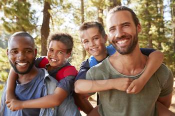 Portrait Of Boys With Fathers On Hiking Adventure Through Forest