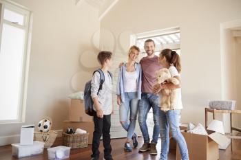 Excited Family In Lounge Of New Home On Moving Day