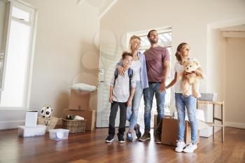 Excited Family In Lounge Of New Home On Moving Day