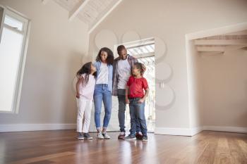 Family Opening Door And Walking In Empty Lounge Of New Home