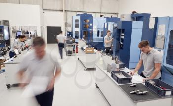 Busy Engineering Workshop With Workers Using CNC Machinery