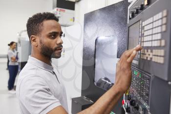 Male Engineer Operating CNC Machinery In Factory