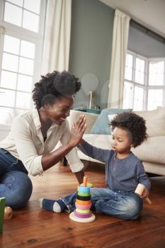 Mother Giving Son High Five As They Play With Toy At Home