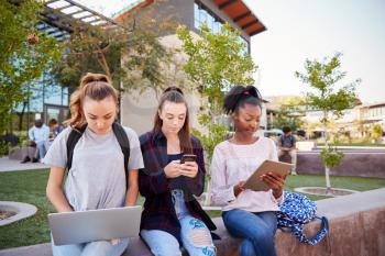 Female High School Students Using Digital Devices Outdoors During Recess