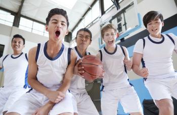 Portrait Of Male High School Basketball Team Celebrating On Court