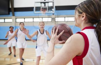 Female High School Basketball Team Passing Ball On Court
