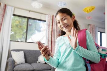 Young Girl With Backpack In Bedroom Ready To Go To School Making Video Call On Mobile Phone