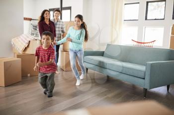 Excited Family Surrounded By Boxes Exploring New Home On Moving Day