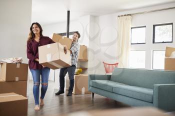 Excited Couple Carrying Boxes Into New Home On Moving Day