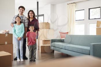 Portrait Of Happy Family Surrounded By Boxes In New Home On Moving Day